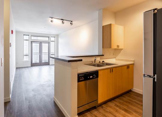 A kitchen with wooden cabinets and a black fridge.