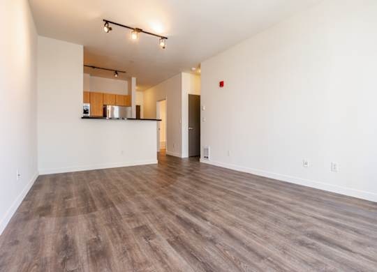 A room with wooden flooring and white walls.