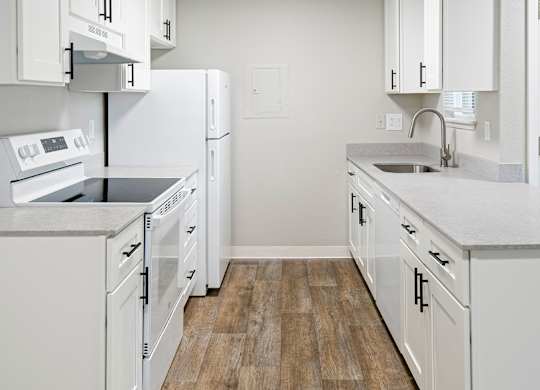 A kitchen with white appliances and cabinets.