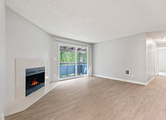 A room with a fireplace and sliding glass doors.