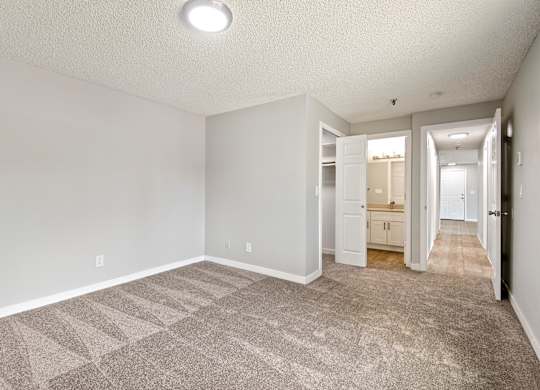 A spacious room with a carpeted floor and white walls.