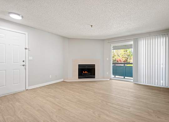 A room with a fireplace and sliding glass doors.