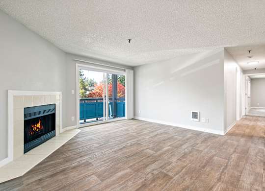 A modern living room with a fireplace and sliding glass doors.