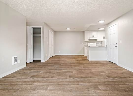 A kitchen area with a refrigerator, cabinets, and a countertop.