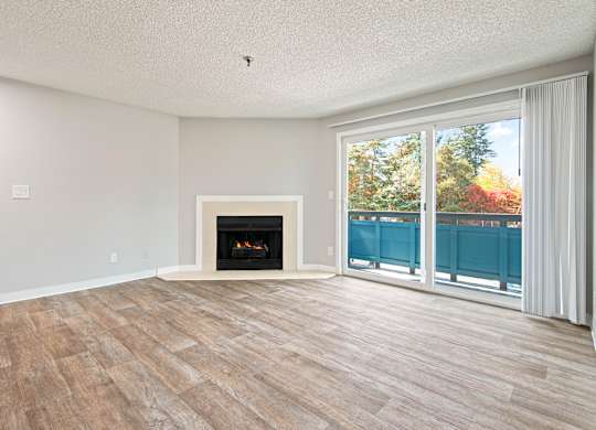 A room with a fireplace and sliding glass doors.