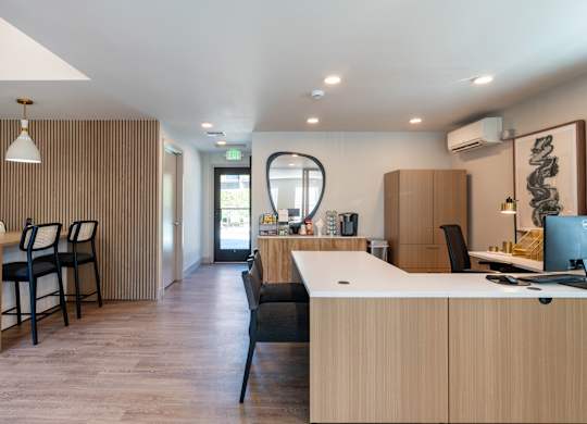 A modern office with wooden furniture and a large window.