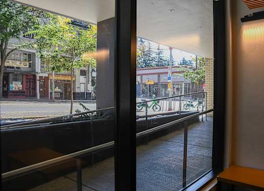 A view from inside a building looking out onto a street with a bike rack.