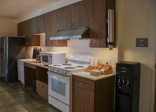 A kitchen with a white stove top oven and a black refrigerator.