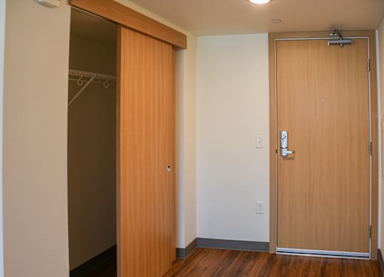 A room with a brown door and a white wall.