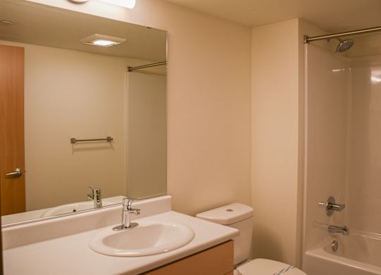 A white bathroom with a sink, toilet, and bathtub.