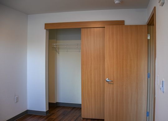 A room with a brown door and a white wall.