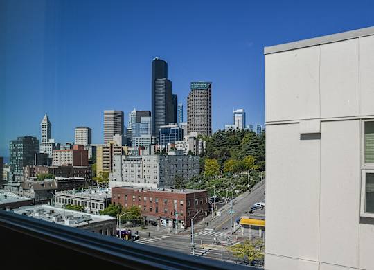 A cityscape with a mix of modern and older buildings is visible from a high vantage point.