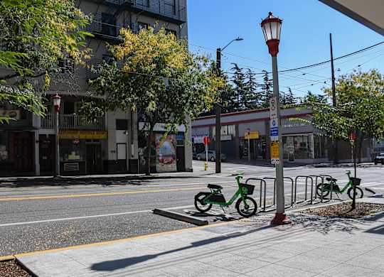 A street scene with a red and yellow street light and a green bike.