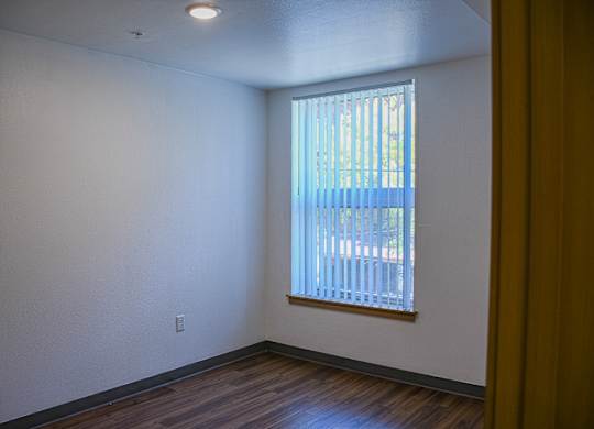 A room with a window and wooden floors.