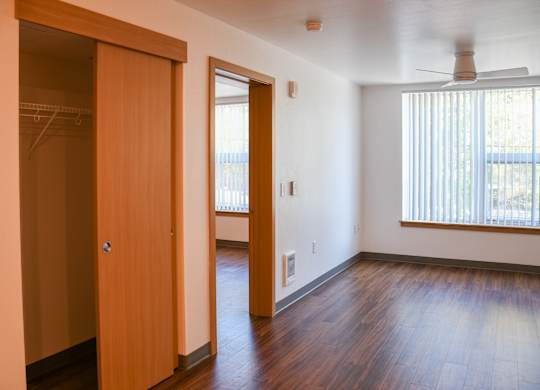A room with a wooden floor and a ceiling fan.