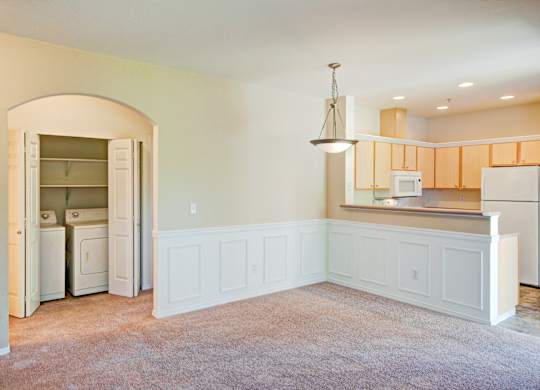 A kitchen with white cabinets and a refrigerator with the door open.