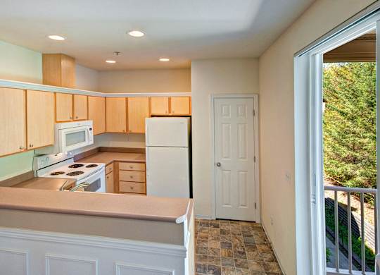 A kitchen with wooden cabinets and a tiled floor.