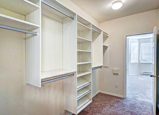 A room with a carpeted floor and a white door.