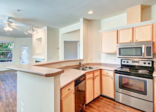 A kitchen with wooden cabinets and stainless steel appliances.