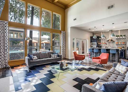 A living room with a grey sofa and a black and white checkered floor.