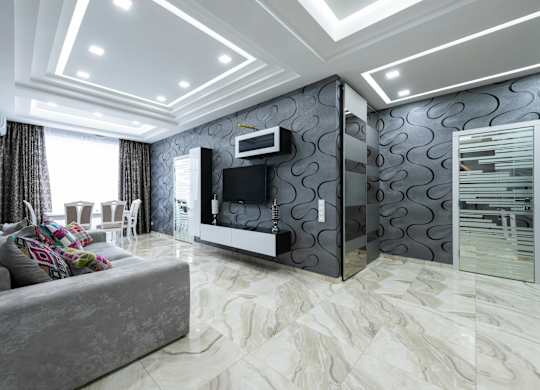 A modern living room with a grey sofa and a television.