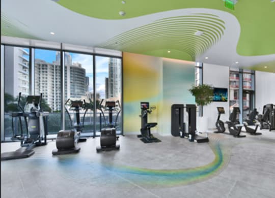 A gym with a variety of equipment including treadmills, stationary bikes, and weight machines.