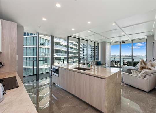 A modern kitchen with a large island and a view of the city.