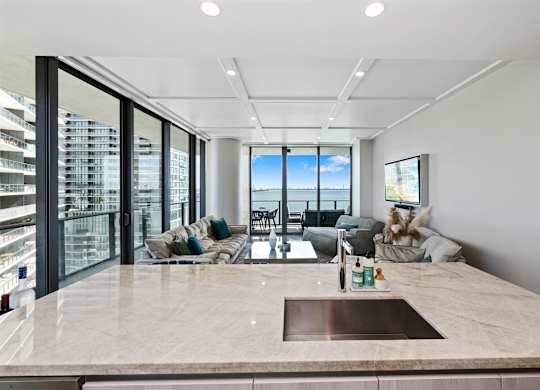 A modern kitchen with a marble countertop and a view of the city.