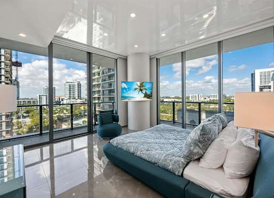 A bedroom with a large bed and a view of the city.