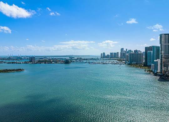 A city skyline is visible from a distance across a body of water.