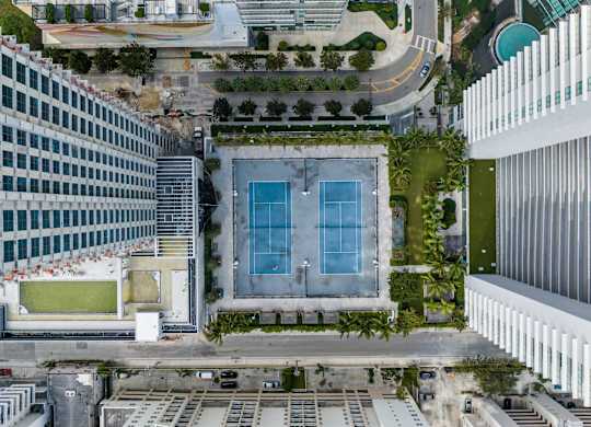 A swimming pool is surrounded by a green lawn and trees.
