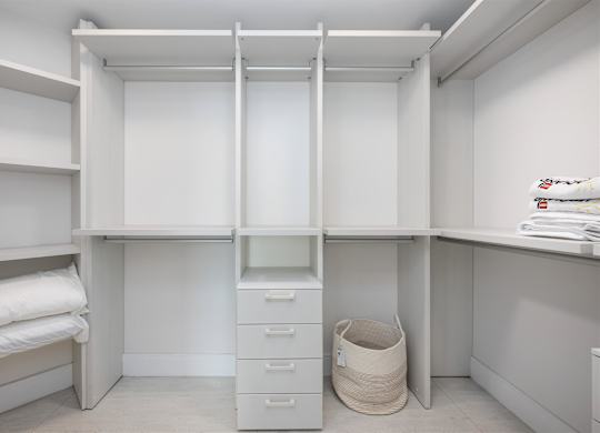 A white closet with drawers and shelves.