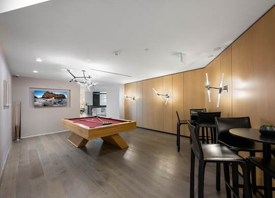 A room with a pool table and a painting on the wall.