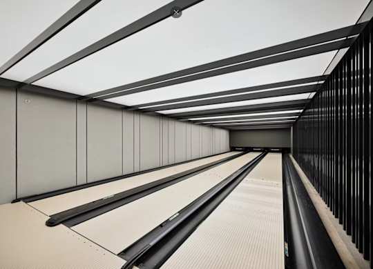 A long, narrow corridor with a reflective floor and walls.