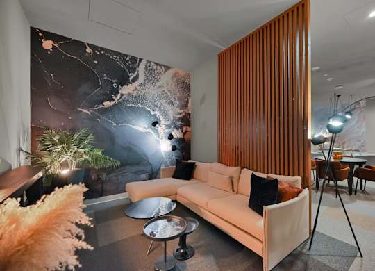 A modern living room with a large mural on the wall.