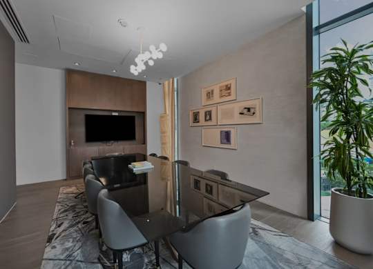 A modern dining room with a long table and chairs.