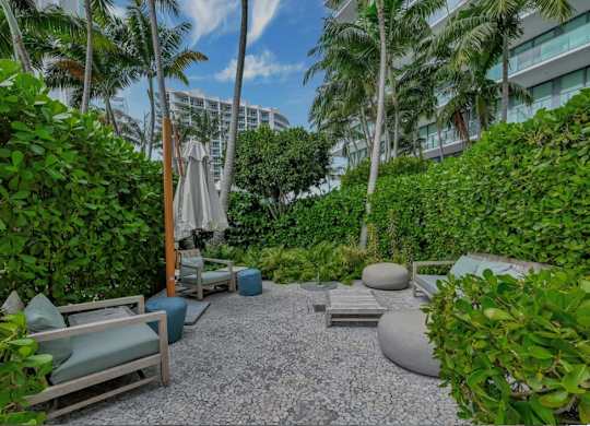 A garden with a gravel path and a white umbrella.