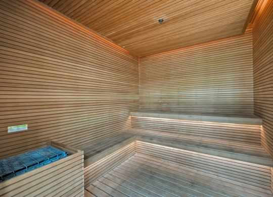 A wooden sauna with a bench and a heater.