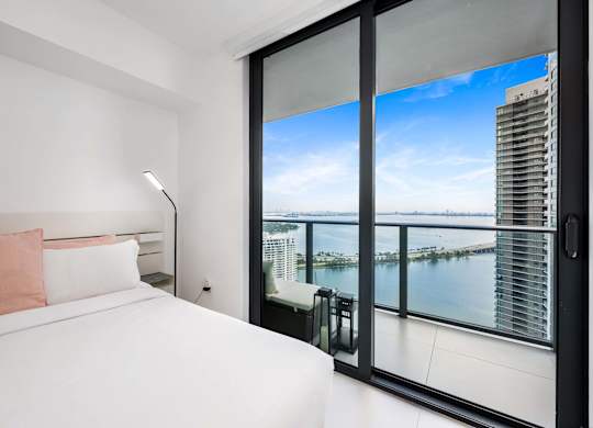 A bedroom with a large bed and a view of the city.