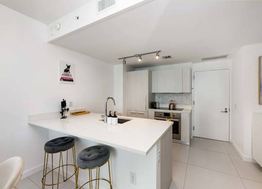 A kitchen with white cabinets and a white counter top.
