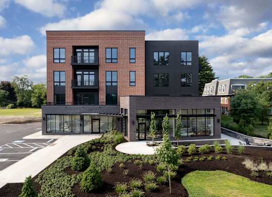 A modern building with a parking lot in front.