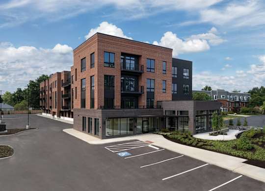 A modern building with a parking lot in front.