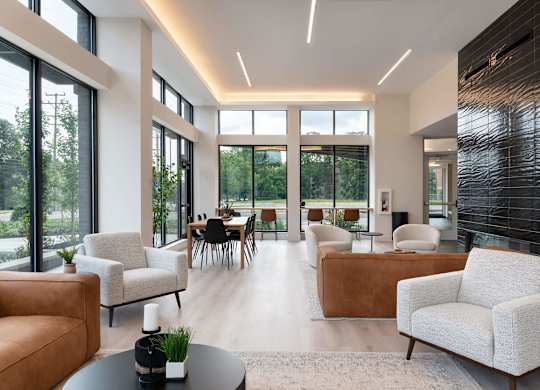 A modern living room with white furniture and a large window.