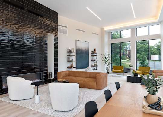A modern living room with a fireplace and a long wooden table.