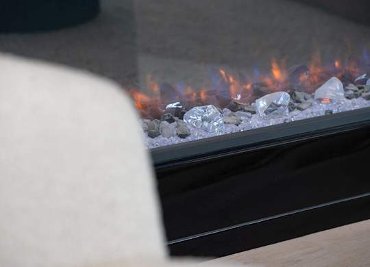 A close up of a fireplace with a fire burning inside.