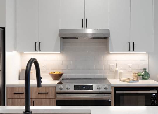 A modern kitchen with a stainless steel range hood above the stove.