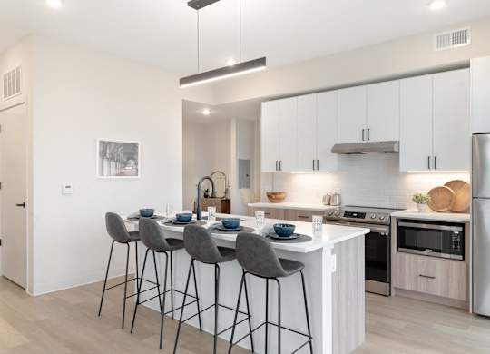 A modern kitchen with a dining table and chairs.