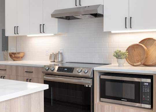 A modern kitchen with a stainless steel oven and microwave.