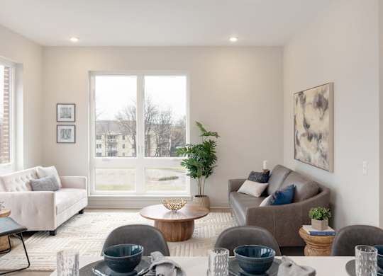 A living room with a couch, chairs, and a table with bowls on it.