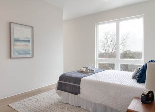 A bedroom with a large bed and a painting on the wall.